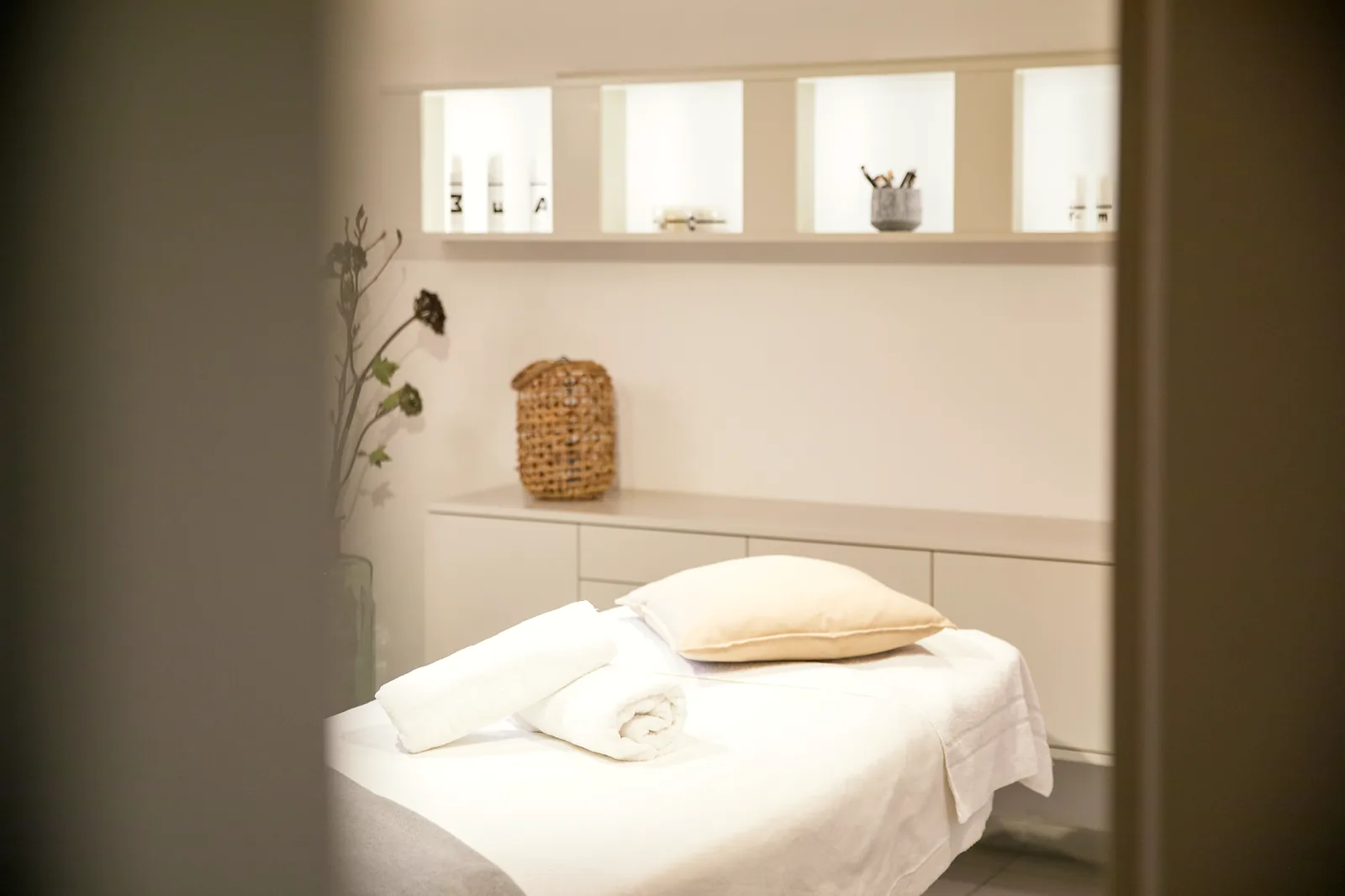 Behandlungsraum mit Massageliege und gefalteten Handtüchern im Spa des Hotel Krone