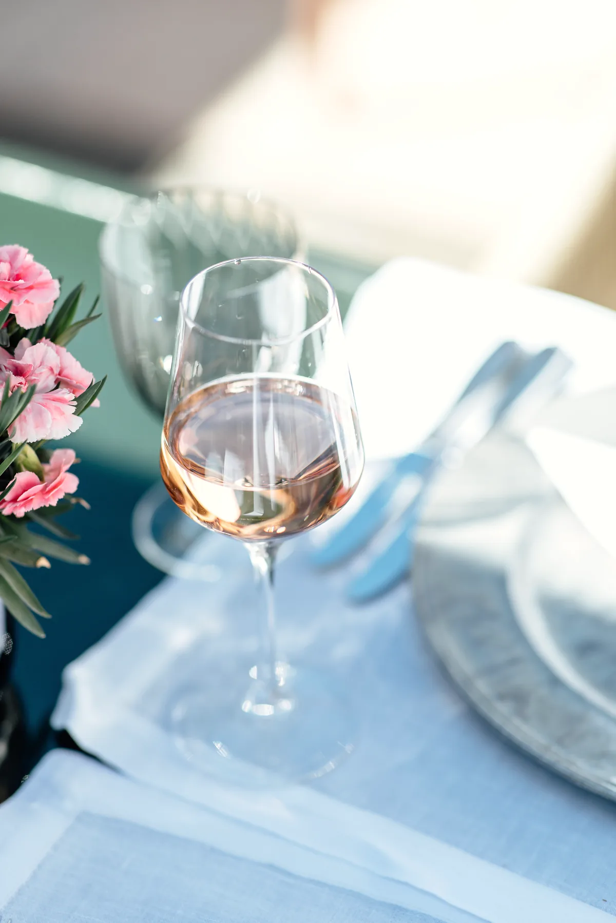 Frische Blumen und ein Glas Wein auf einem gedeckten Tisch der Terrasse des Hotel Krone