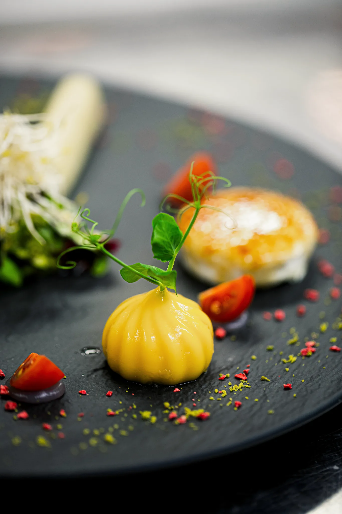 Dessert-Degustation mit Küchlein, Crème brûlée und Aprikosenkompott auf schwarzem Schieferteller