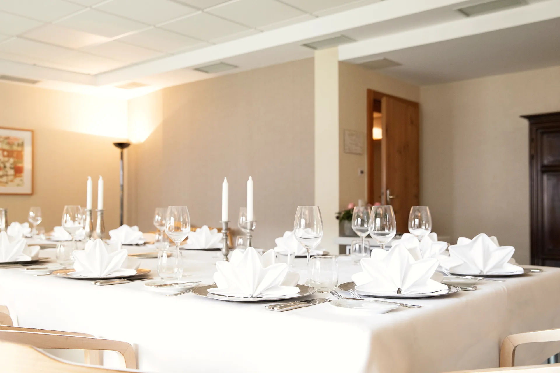 Lange, festlich gedeckte Tafel mit Blumen in einem hellen Séparée des Hotel Krone
