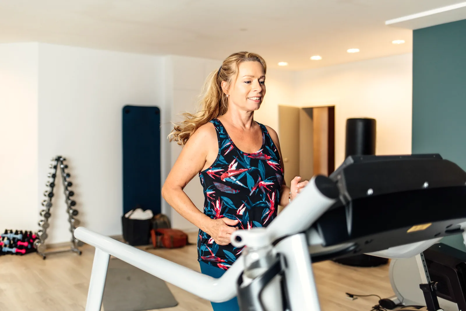 Frau trainiert an einem Gerät im Fitnessraum des Hotel Krone