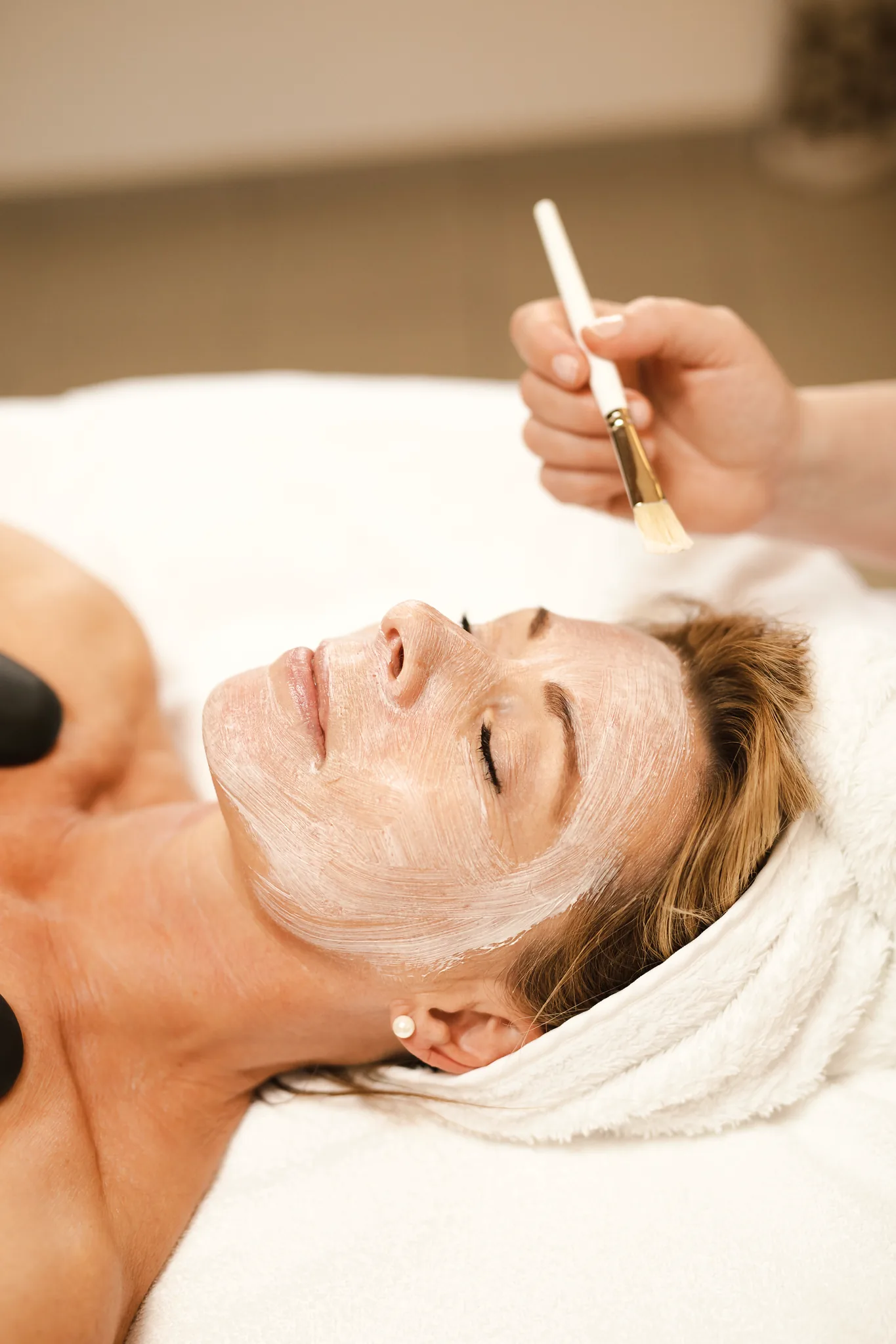 Gesichtsmaske wird bei einer Behandlung im Spa des Hotel Krone aufgetragen