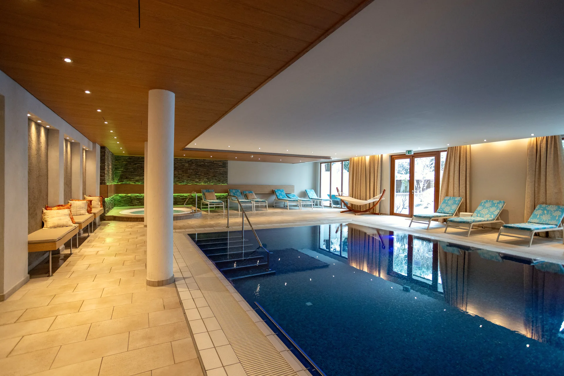 Innenpool des Hotel Krone in voller Breite mit Holzdecke und Liegen