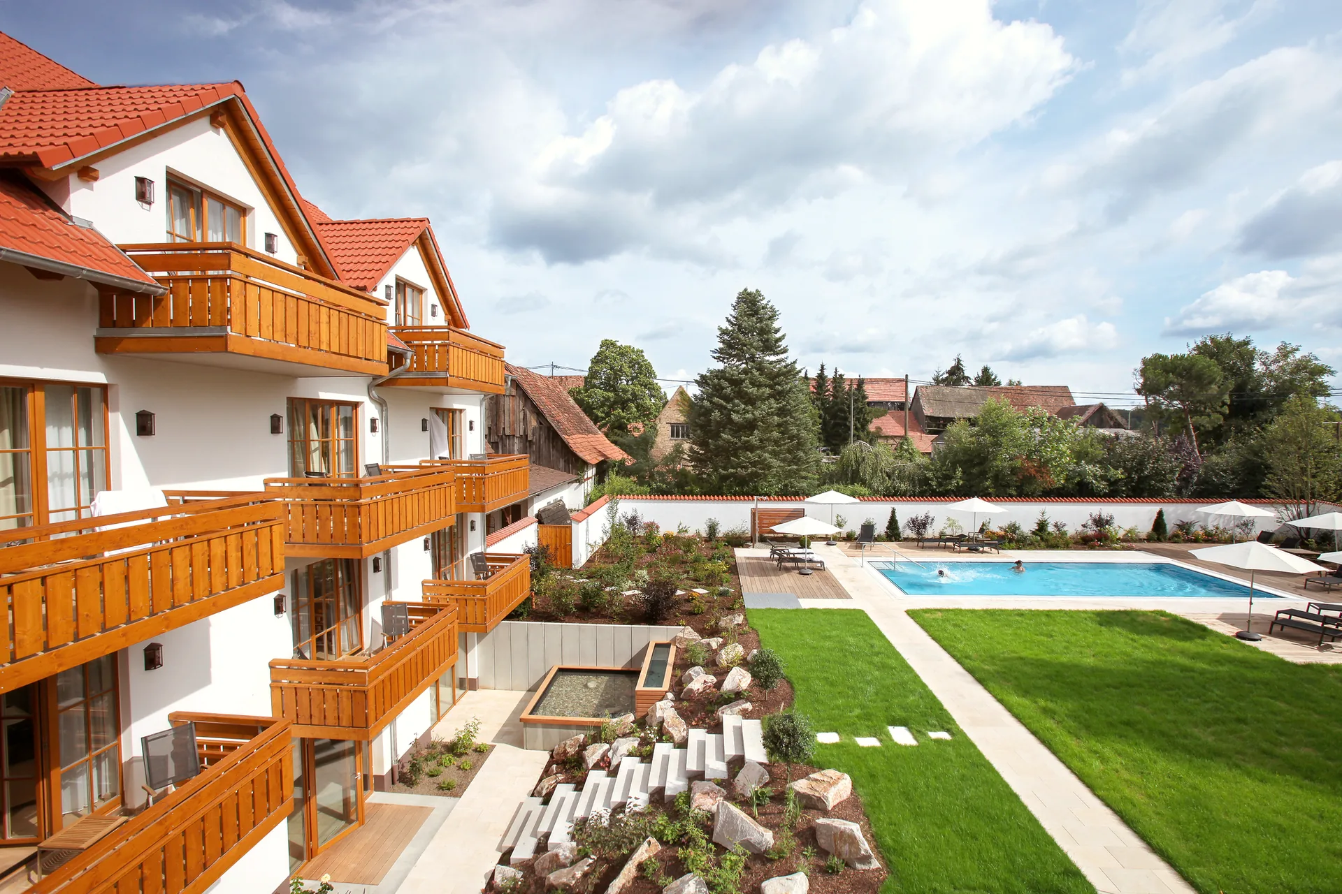 Luftaufnahme von Garten, Rasen und Außenpool des Hotel Krone im Sommer