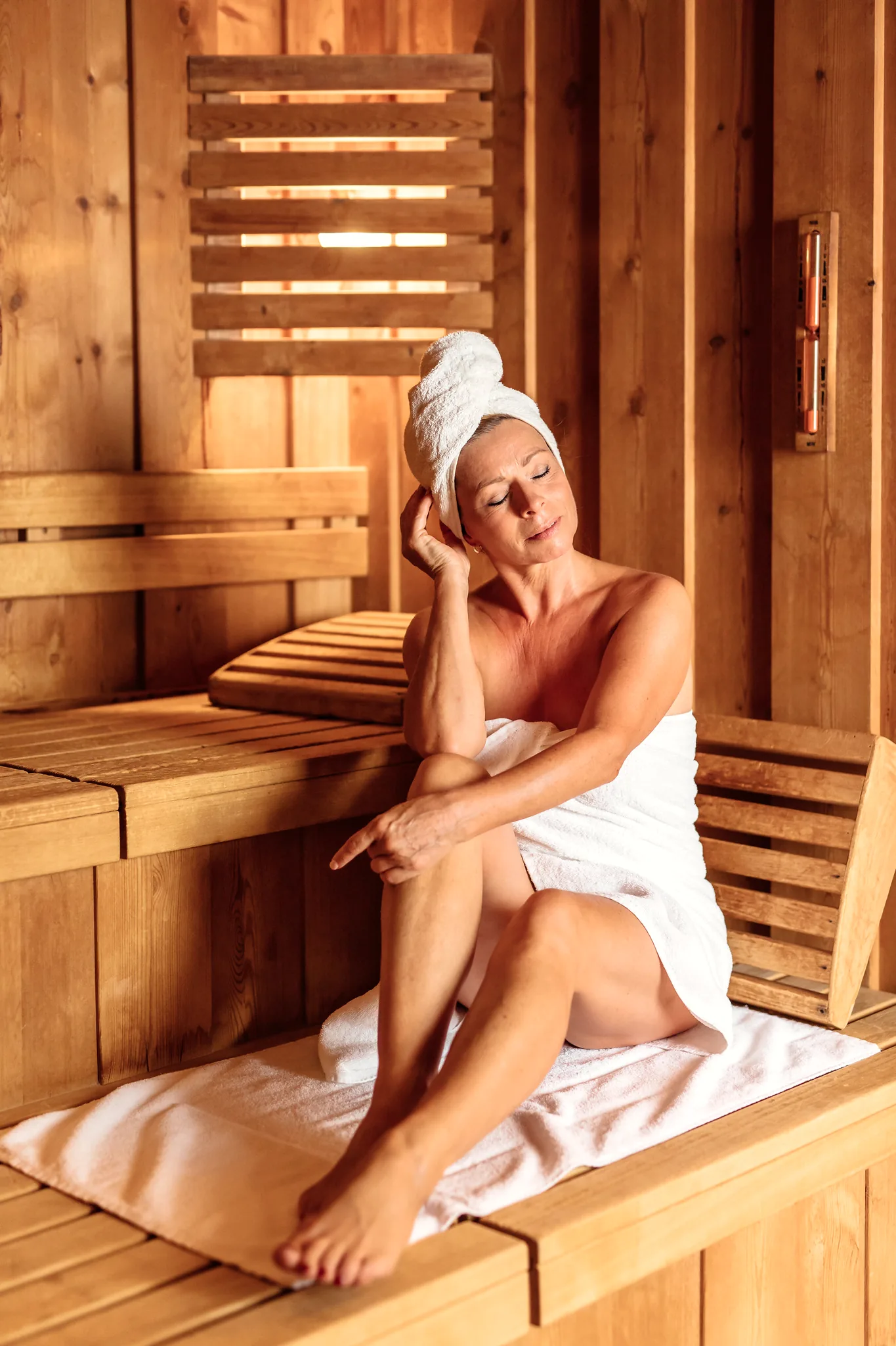 Frau im Handtuch entspannt in der Holzsauna des Hotel Krone