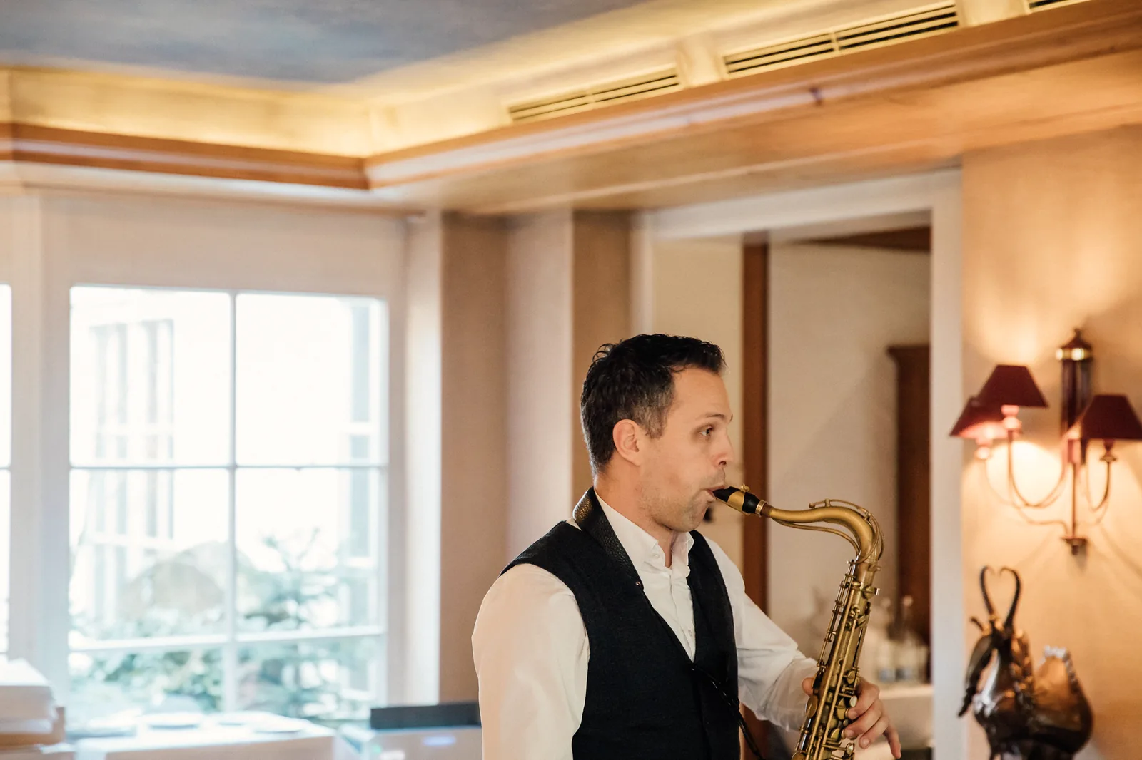 Saxophonist spielt im Erker des Restaurants im Hotel Krone