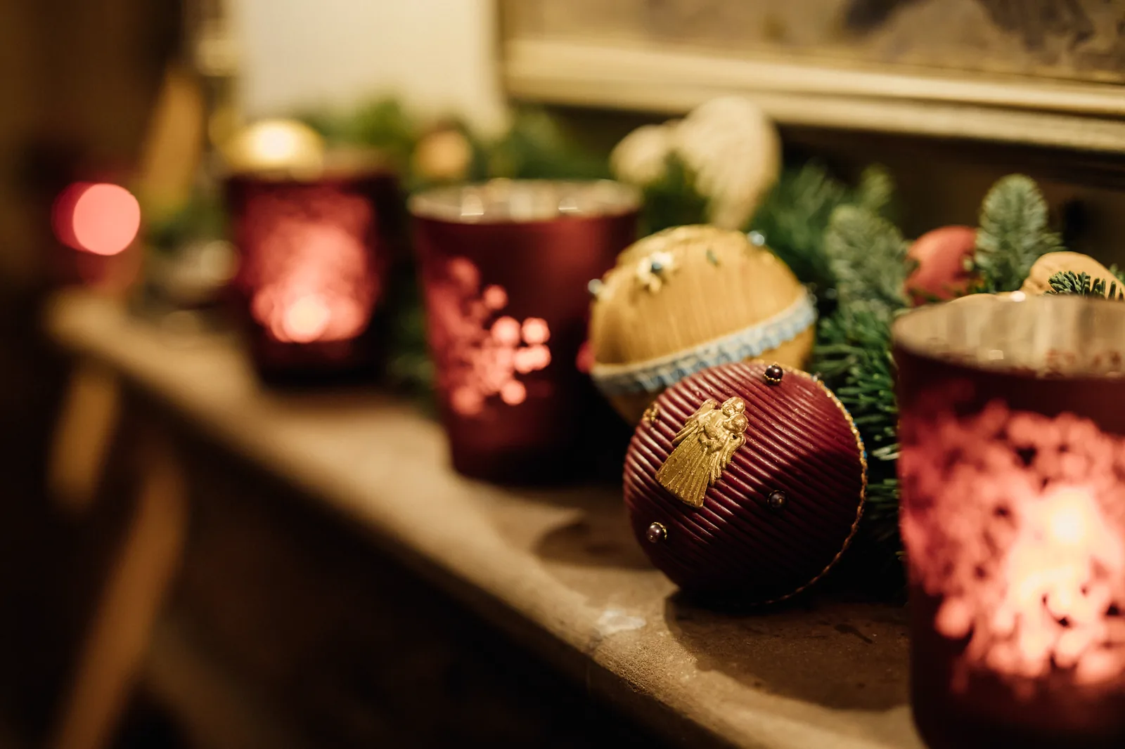 Teelichter in roten Gläsern auf einem Kaminsims im Advent im Hotel Krone