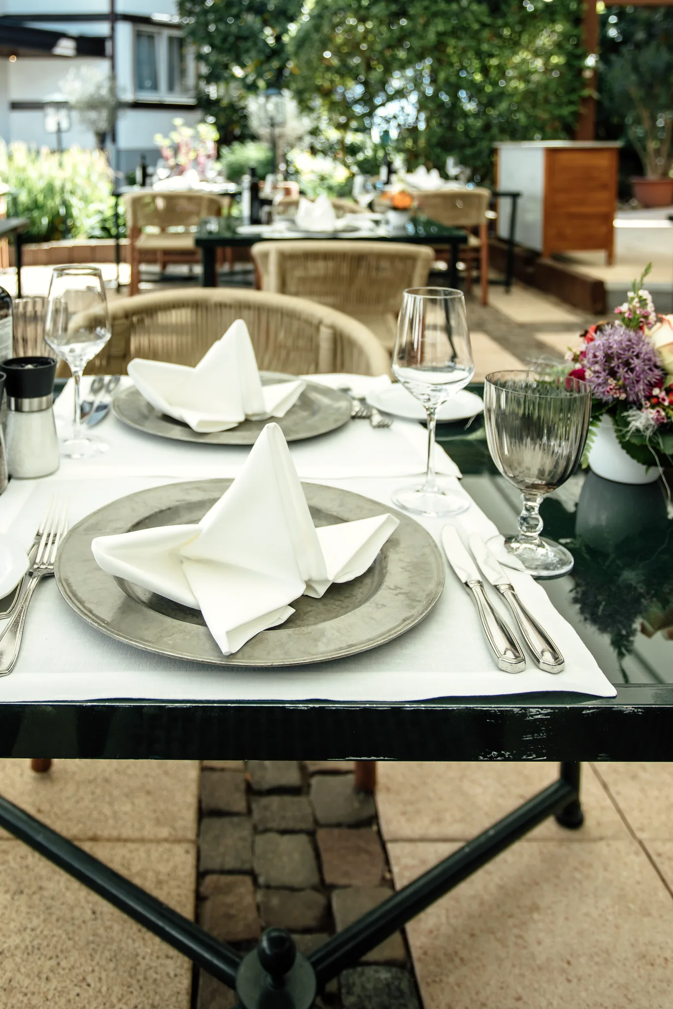 Gedeckter Tisch mit Weinflasche, Gläsern und Blumen auf der Terrasse des Hotel Krone