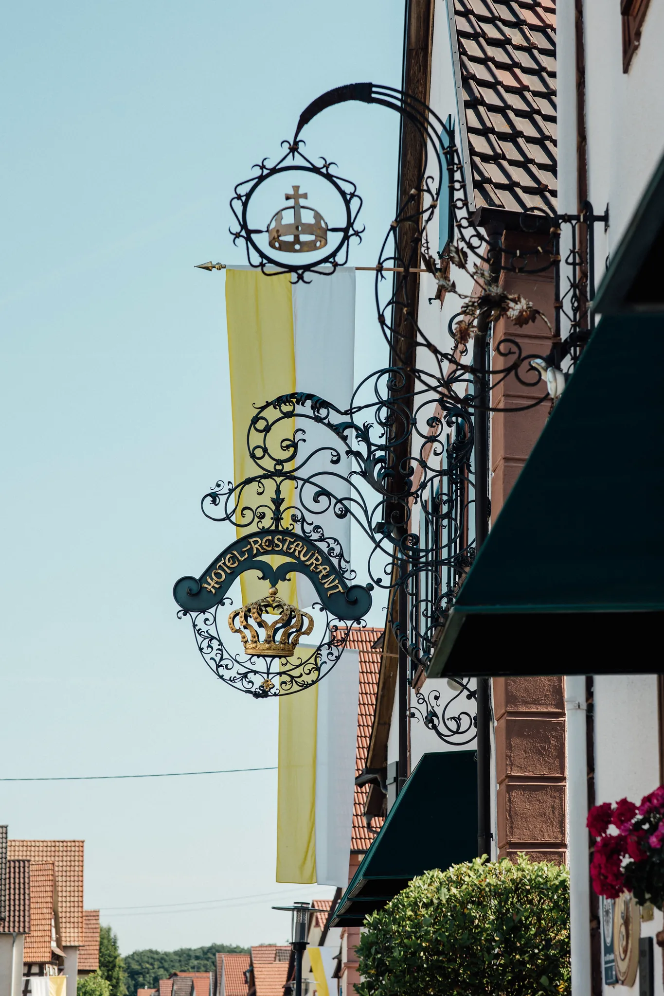 Detail des schmiedeeisernen Wirtshausschilds mit Krone an der Fassade