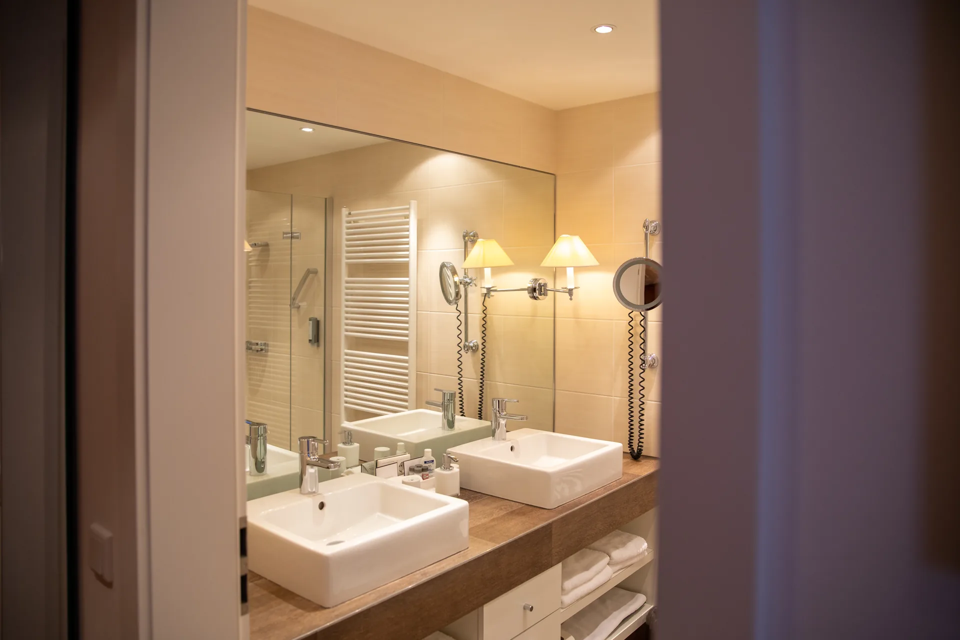 Bad mit Waschtisch, Spiegel und Glasdusche in einem Zimmer des Hotel Krone