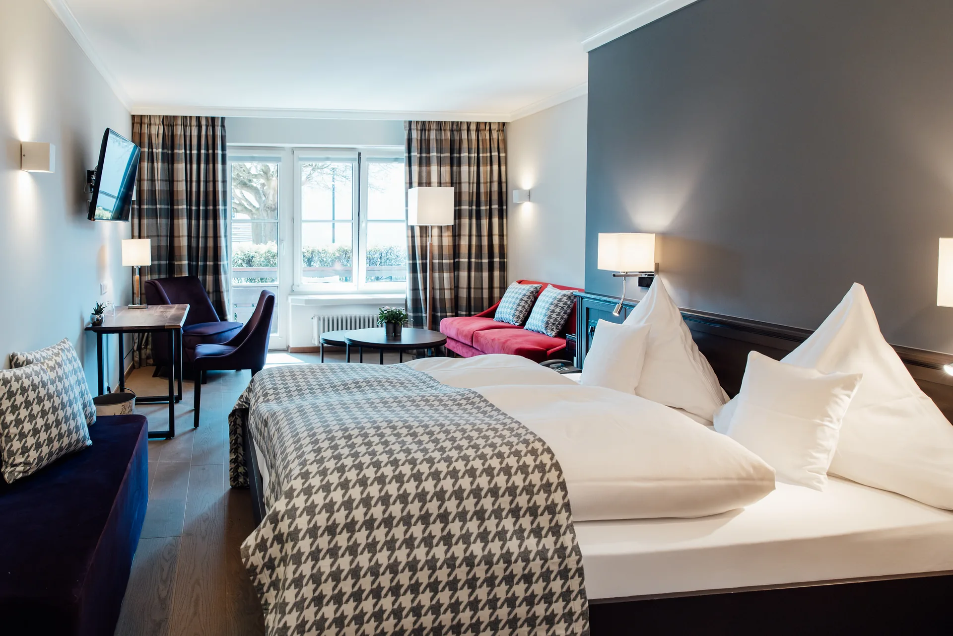 Renoviertes Doppelzimmer Classic mit grauer Karodecke, Schreibtisch und Fernseher