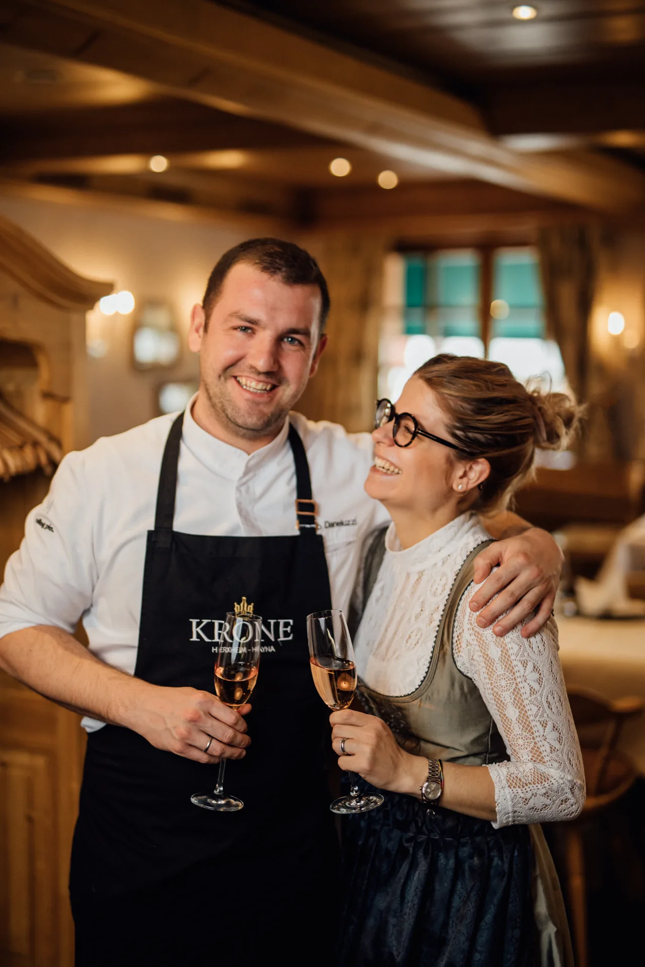 Erika und Fabio Daneluzzi mit Sektgläsern in der Küche der Krone