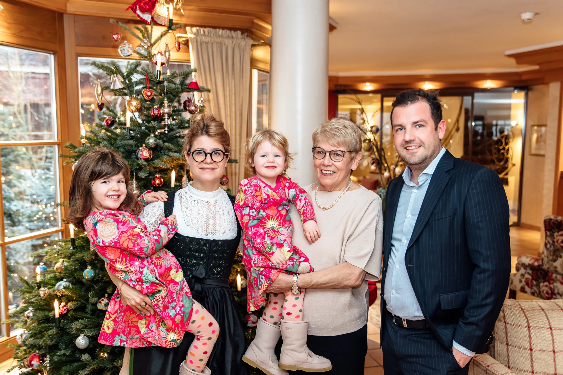 Erika und Fabio Daneluzzi mit ihren Kindern und Seniorchefin Karin Schlindwein vor dem Weihnachtsbaum in der Hotelhalle der Krone