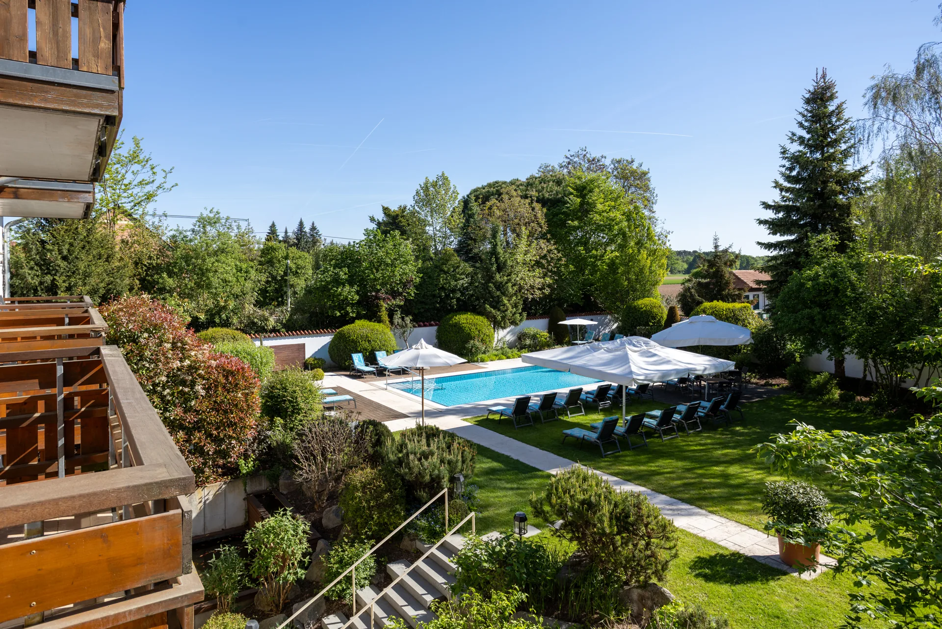 Garten mit Außenpool, Liegen und Sonnenschirmen des Hotel Krone von oben
