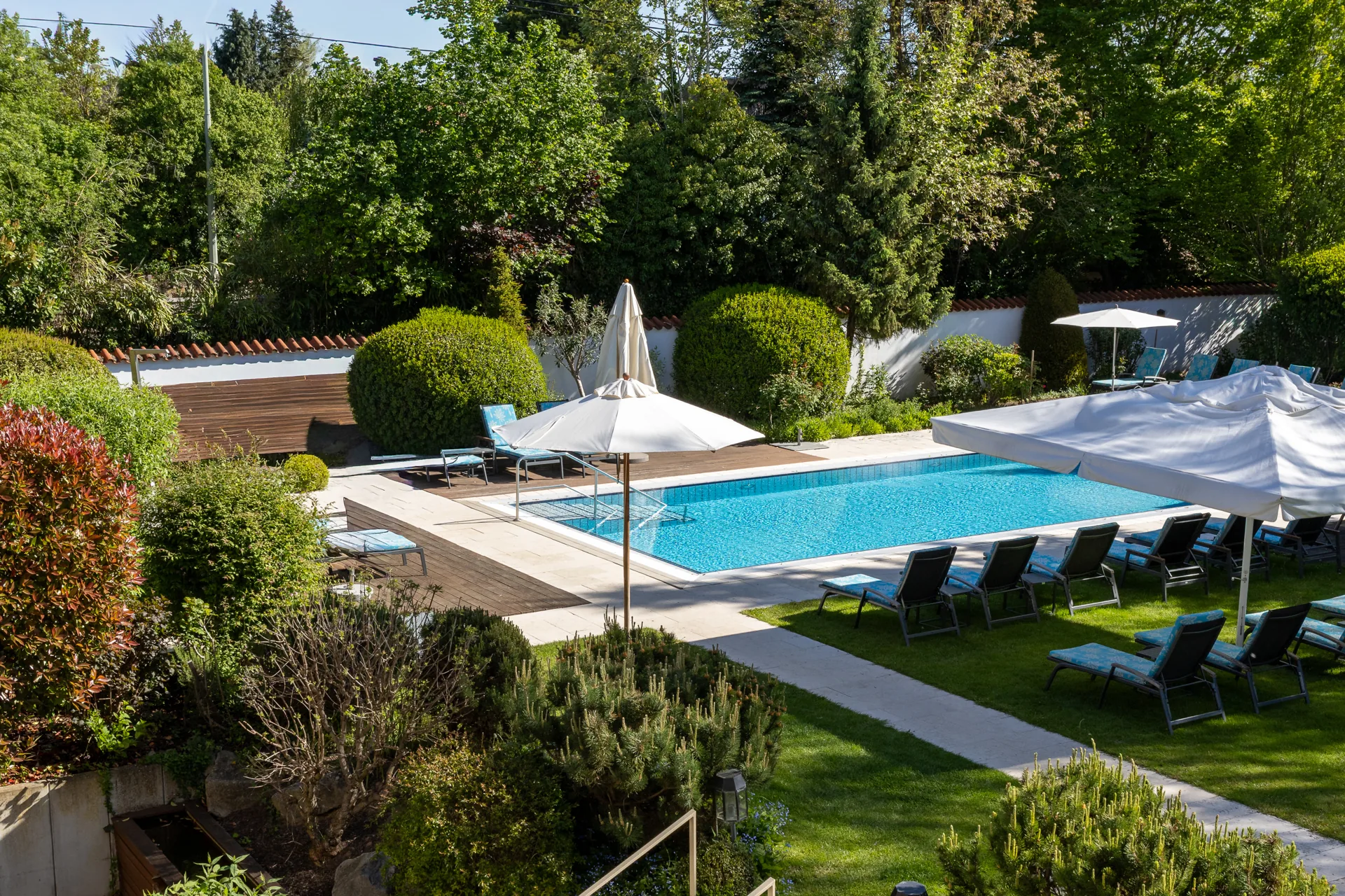 Blick von oben auf Garten und Außenpool des Hotel Krone im Sommer