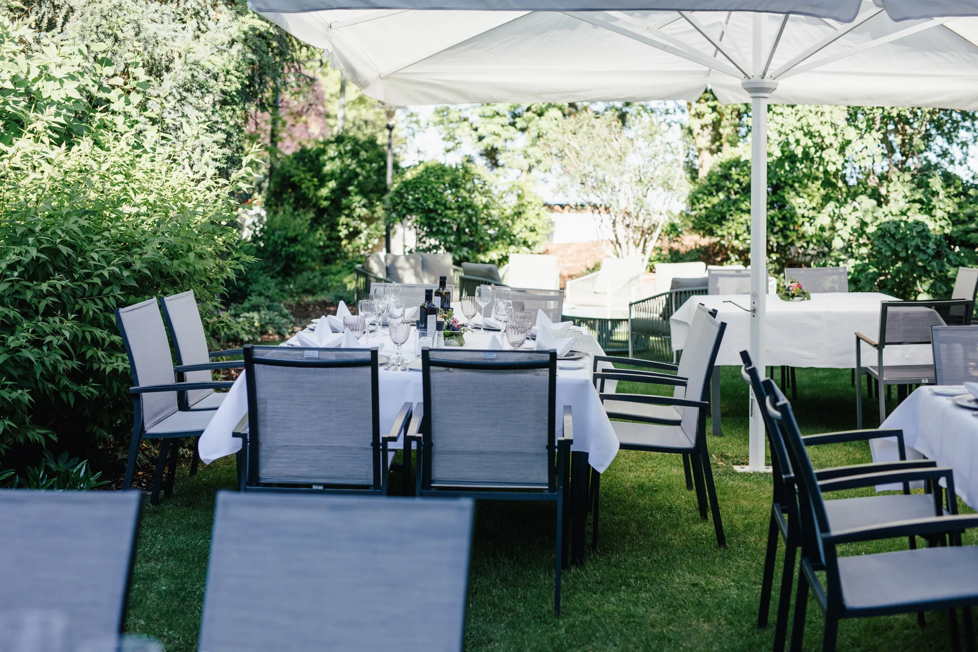 Gedeckte Tafel unter Sonnenschirmen im Garten des Hotel Krone