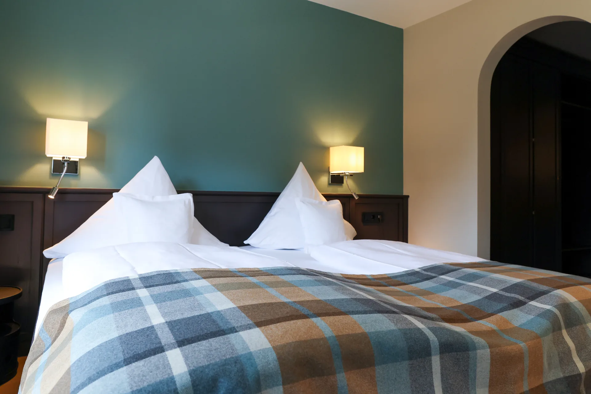 Junior Suite mit Doppelbett, Karodecke und petrolfarbener Wand