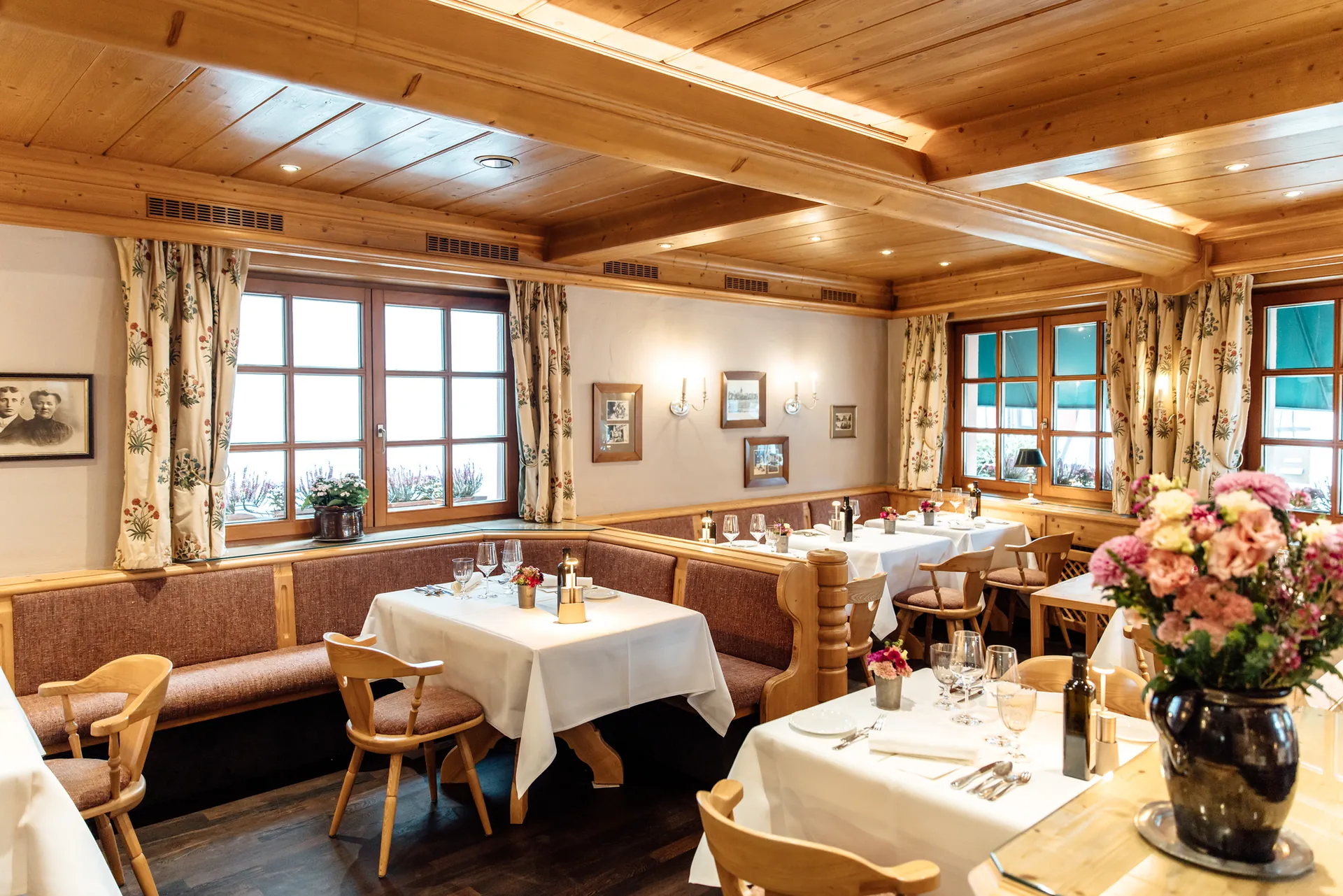 Gedeckte Tische mit weißen Decken und Blumenstrauß in der holzvertäfelten Pfälzer Stube