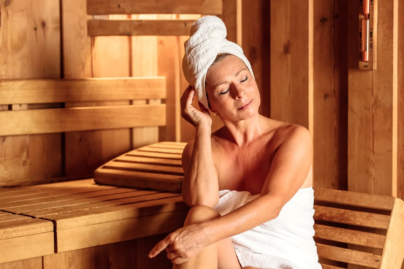 Frau im Handtuch entspannt in der Holzsauna des Hotel Krone