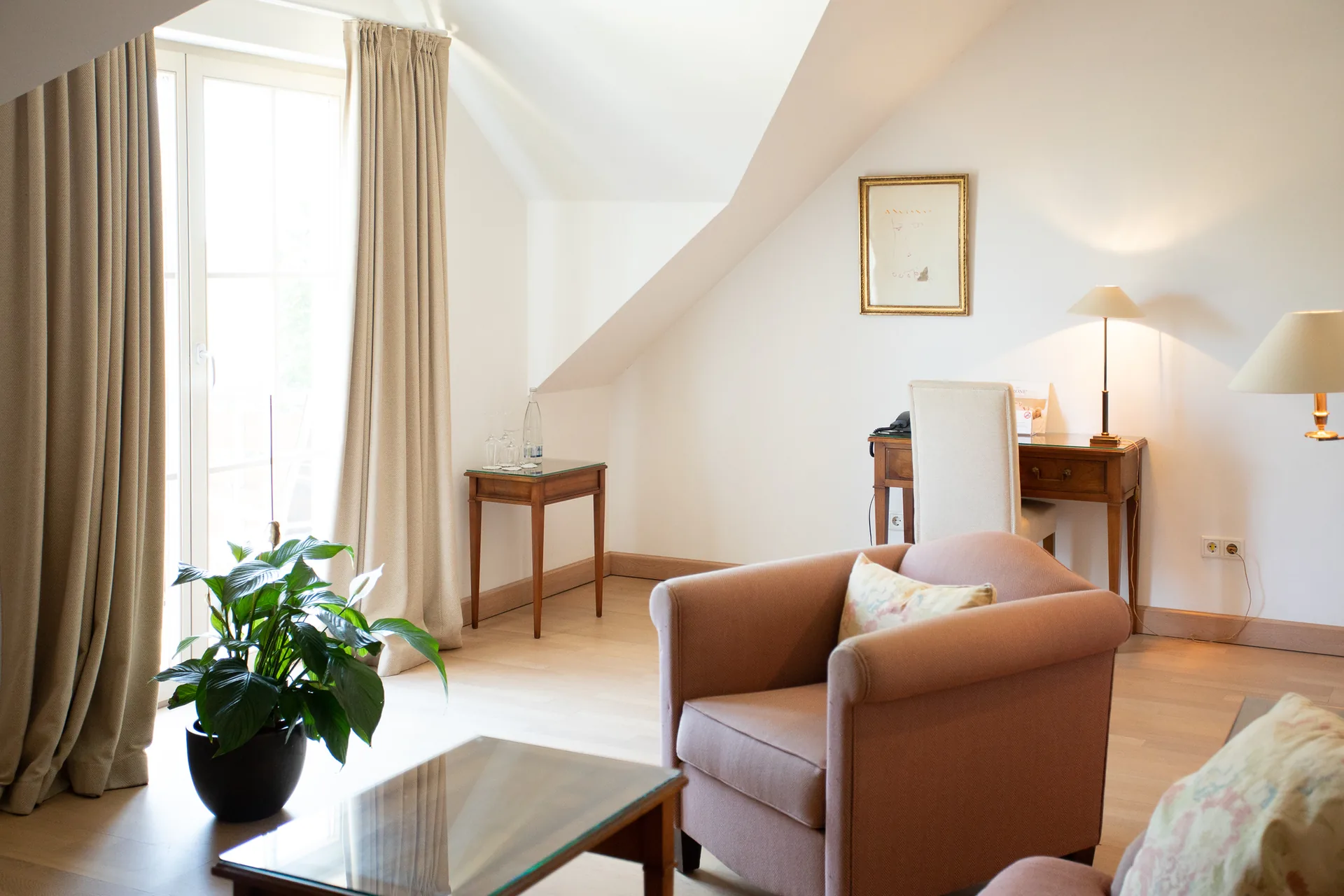 Wohnbereich der Suite mit Sesseln, Pflanze und Fenster unter der Dachschräge